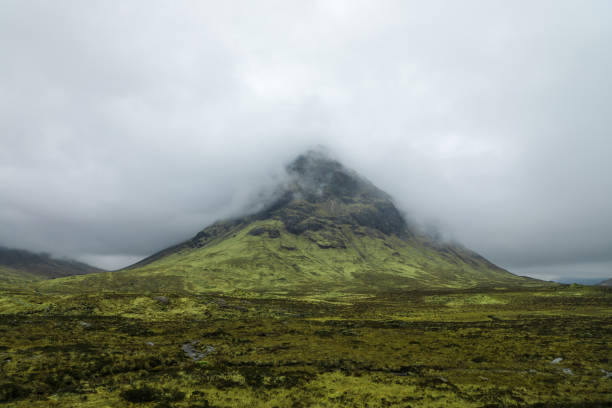 Dramatic Buachaille Etive Beag peak in Glencoe Scottish Highlands View of the green peak of Buachaille Etive Beag nestled in the clouds on a spring day in Glencoe Scottish Highlands buachaille etive beag photos stock pictures, royalty-free photos & images