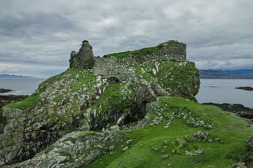 Ruins of the seaside Dunscaith Castle in the Isle of Skye Scotland on a moody cloudy day