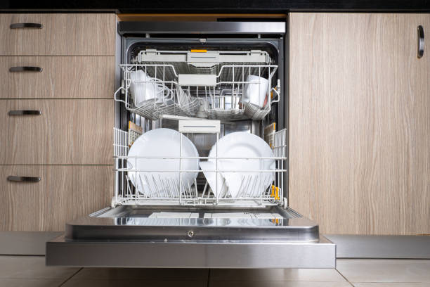 Open door of built-in dishwasher. Kitchen with integrated appliances. Plates and dishes in the dishwasher. Open door of built-in dishwasher. Kitchen with integrated appliances. Plates and dishes in the dishwasher. glass steel contemporary nobody stock pictures, royalty-free photos & images