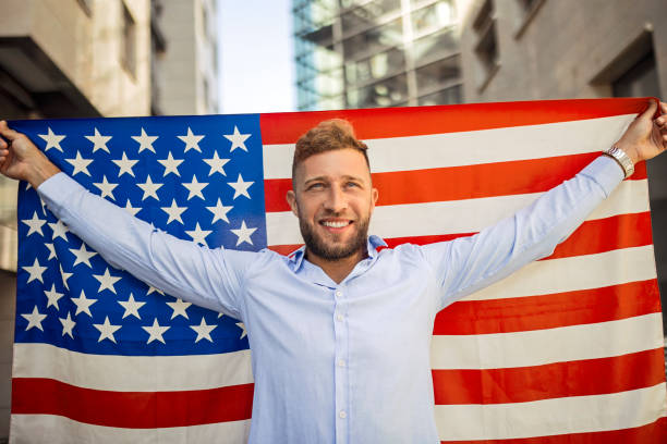 istock Young handsome man posing with American flag looking at camera 1403872199