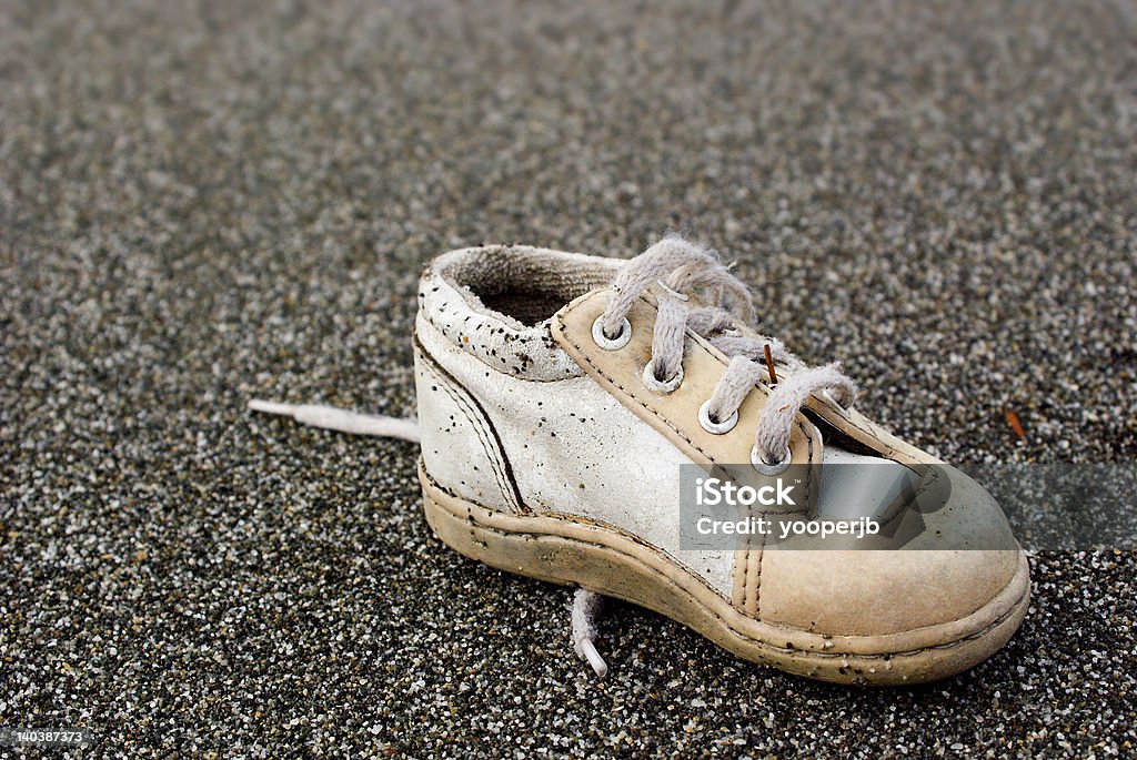 Baby Shoe on Beach Baby shoe found on a Beach in Northern California. Close-up Macro photography. Baby Booties Stock Photo