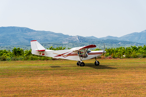 Ultralight plane taking off on a grass runway.