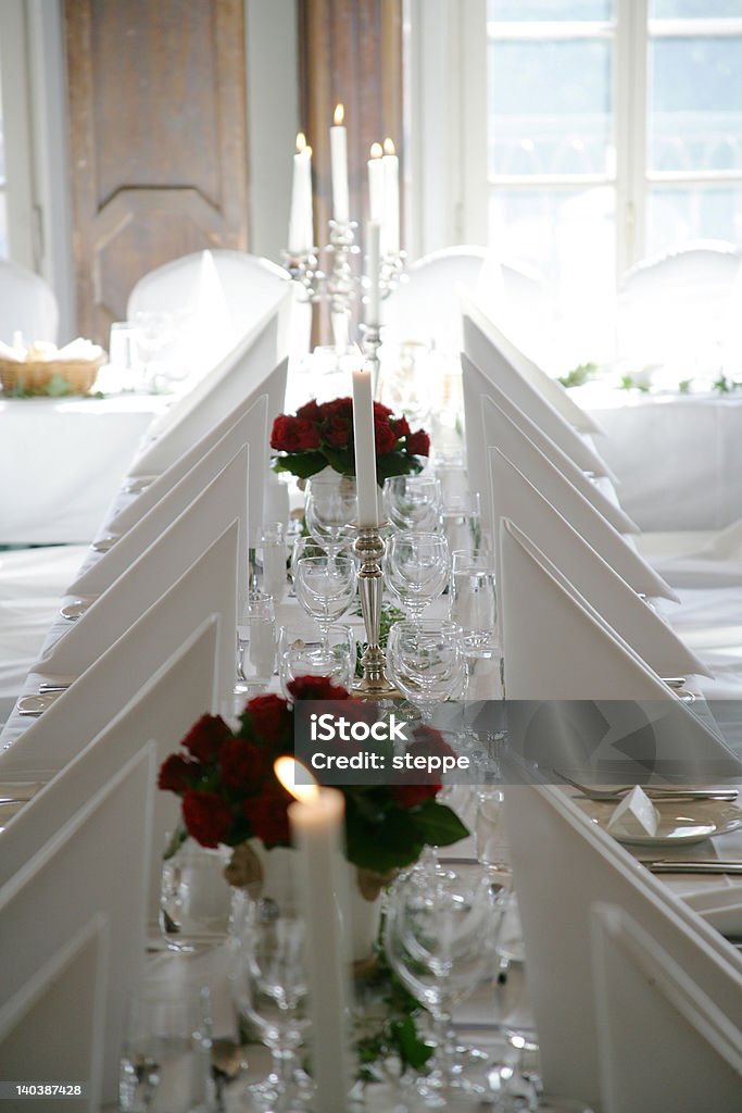 Welcome to the dinner Dinner table with red roses and lit candles, ready for a nice evening. Arranging Stock Photo