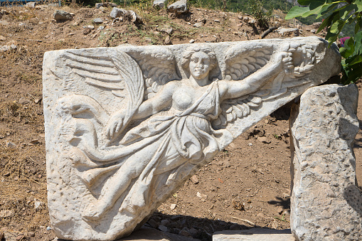 Stone carving of goddess Nike, Ephesus or Efes, Kusadasi, Turkey. Marble relief of winged Nike Goddess of Victory Ephesus Turkey. Carved marble statue. Sculpture of goddess Nike in archaeological site of ancient Ephesus.