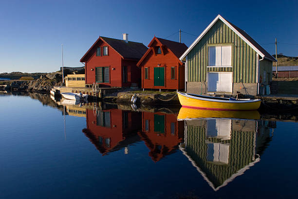 Boathouses with reflection, Kvtsoey Island, Norway. stock photo