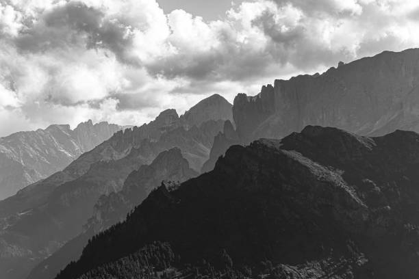 mountain ridges in black and white on the dolomites with a cloudy sky