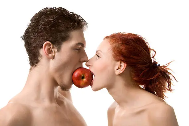 Couple biting an apple, isolated on white