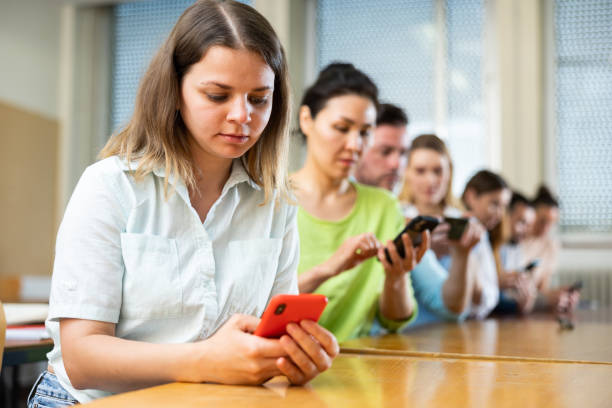 istock Fellow students play with their smartphones 1403886417