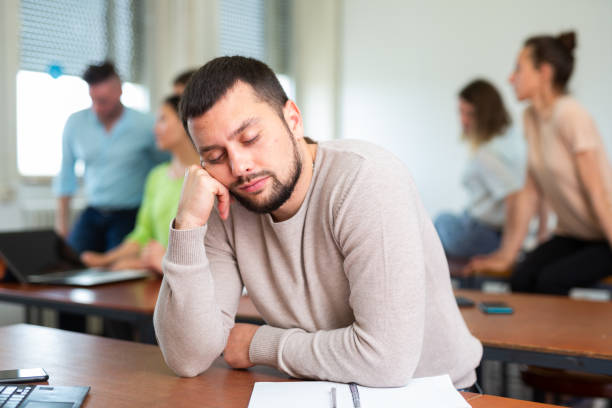 istock Tired man fell asleep at a lecture in university auditorium 1403886506