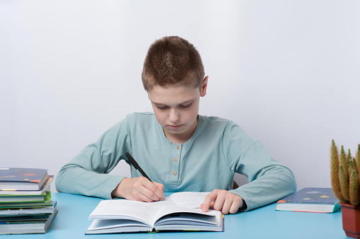 A pupil completes his homework in the copybook