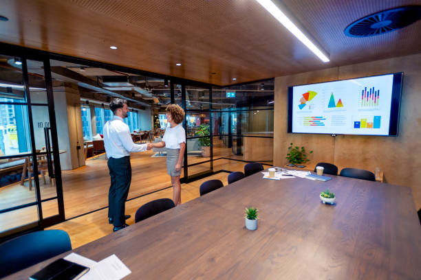 istock Man and woman handshake in a board room. 1403889095