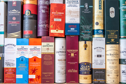 Calgary, Alberta - June 19, 2022: Single malt scotch whisky display boxes and tubes as background.