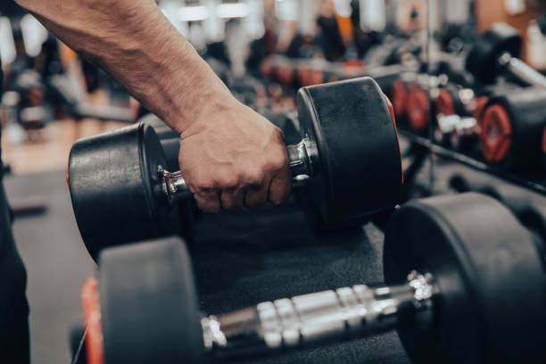 istock dumbbells in the gym with hand 1403890628