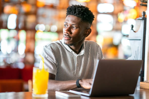 istock Young African man using laptop at cafe 1403891794