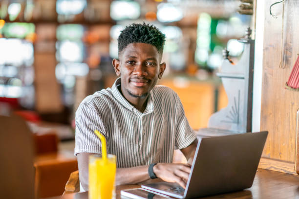istock Young African man using laptop at cafe 1403891803