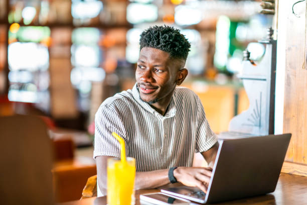 istock Young African man using laptop at cafe 1403891809