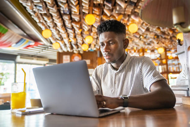 istock Young man working on laptop at cafe 1403894238