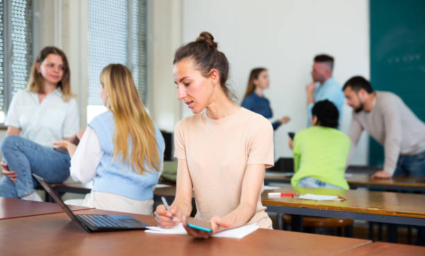 istock Woman university student writing in classroom 1403894410