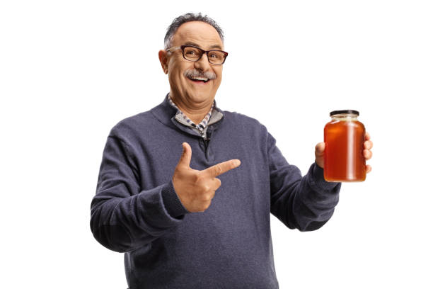 istock Mature man holding a honey jar and smiling 1403896414