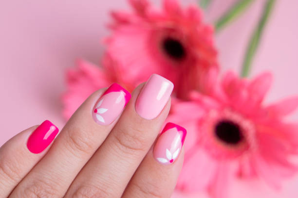istock Female hands with pink manicure, flowers design 1403905555