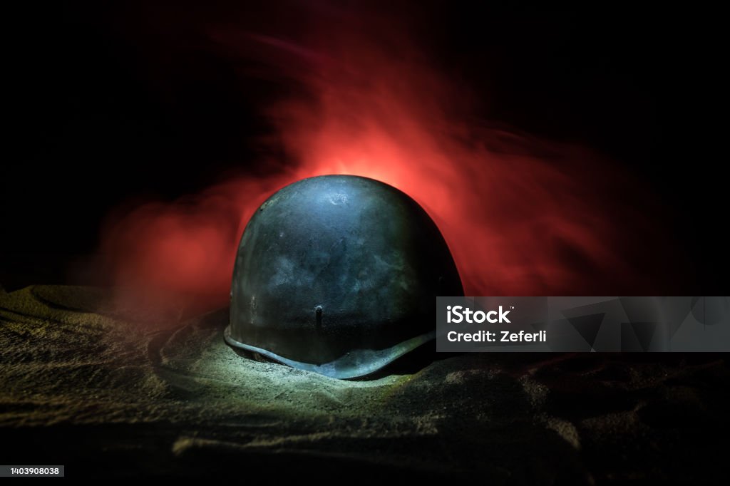 Soviet army Helmet Second World War in dark. Selective focus Soviet army Helmet Second World War on sand with backlight and smoke. War concept. Selective focus Helmet Stock Photo