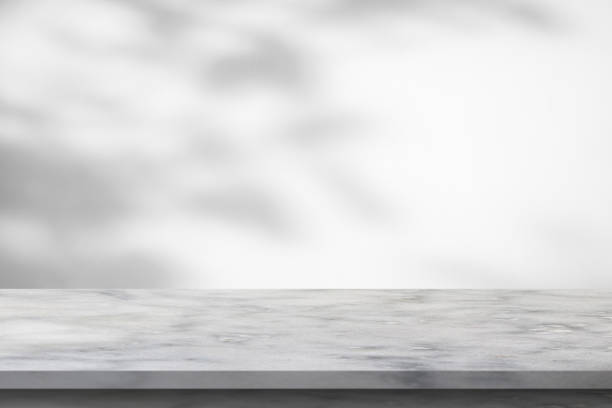 istock Marble table with tree shadow drop on white wall background for mockup product display 1403910448