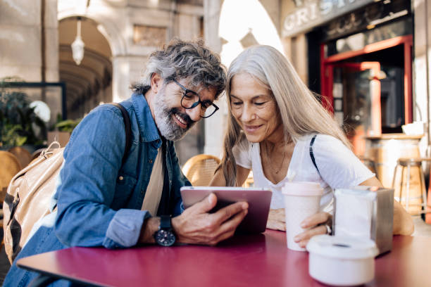 istock Mature couple on a journey enjoying at the cafe and using tablet 1403910515