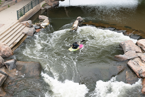 Denver, Colorado, May 28, 2022. Man kayaking on the South Platter River along the trail and near the bridge