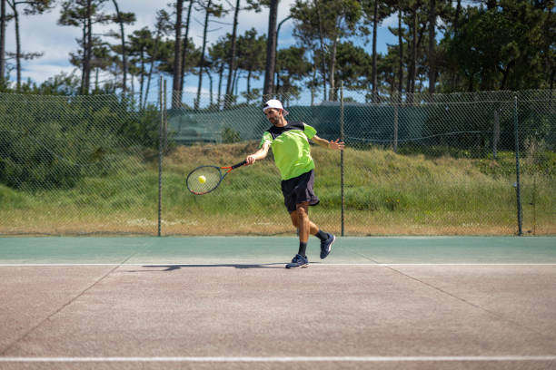 joueur de tennis frappant un coup droit à la balle - forehand photos et images de collection