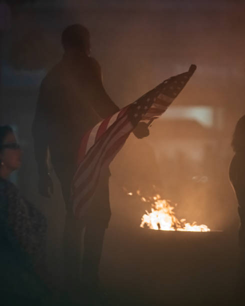 Person holding an American Flag at a Mock Protest