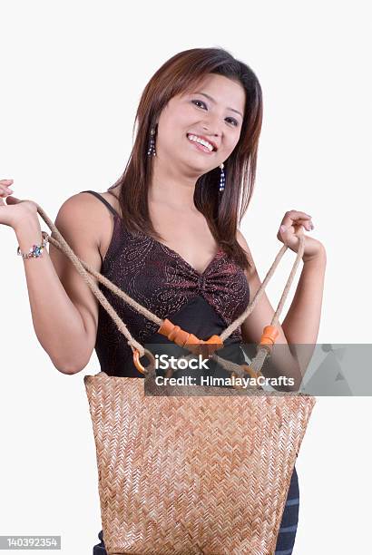 Donna Con Una Borsa A Mano E Sorridenti - Fotografie stock e altre immagini di 20-24 anni - 20-24 anni, Abbigliamento, Abbigliamento casual