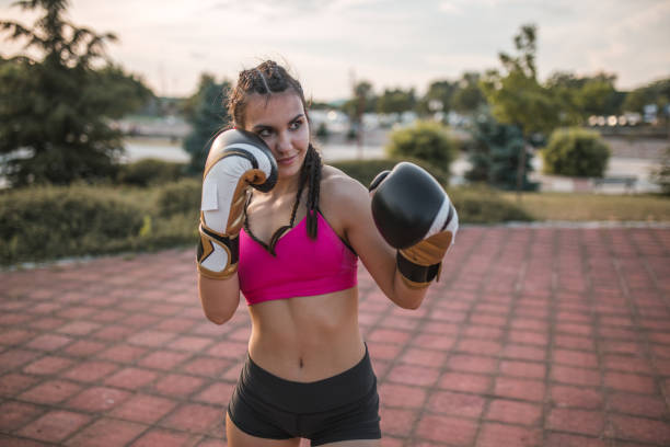 istock Smiling female kickboxer trains in the public park 1403929582