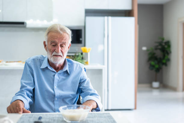 An elderly man has anorexia. Can't eat rice in the morning of the day stock photo