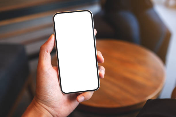 Mockup image of a man holding mobile phone with blank white screen in cafe stock photo