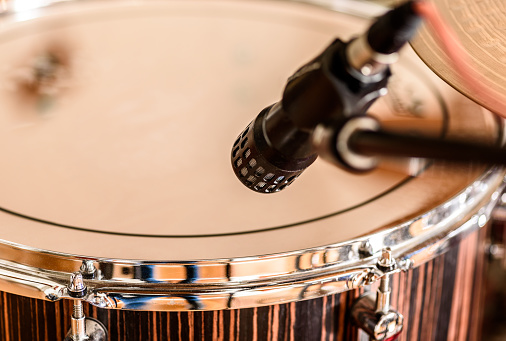 A microphone is placed on a drum set ready to be recorded in a recording studio