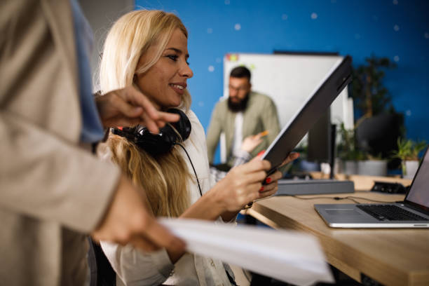 istock Young businesswoman smiling while analyzing a document her colleague is showing to her 1403939873