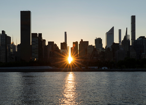 Manhattan skyline silhouette at sunset.