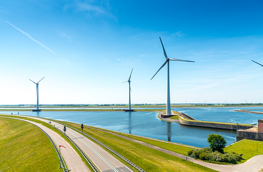 An empty dutch  road and a row of wind turbines. Summer  day in Zeeland, the Netherlands