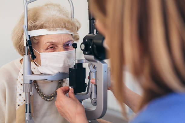 istock senior woman checking eyesight in clinic 1403945208