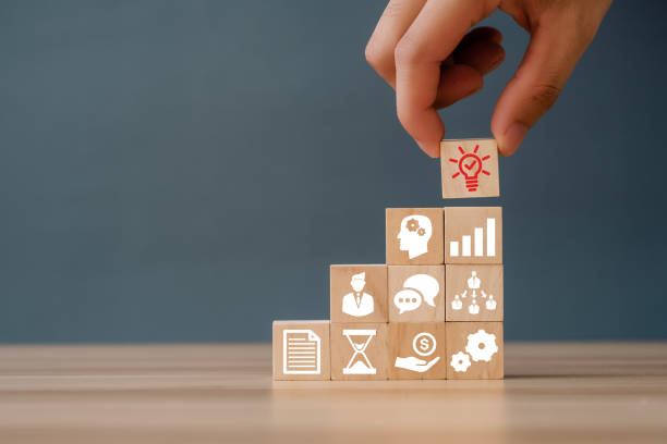 istock Hand puts the wooden cubes with light bulb on hand icon on beuatiful grey background and copy space. New idea, solution, suggestion concept. 1403945906