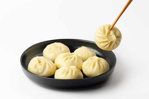 Xiao Long Bao or Baozi, is a type of yeast-leavened meat filled buns, steamed. Chinese dish. White background.