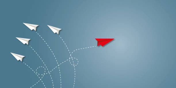 istock Red paper plane change direction from group on dark grey background as metaphor for business creativity new idea. 1403947744
