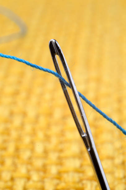 istock sewing needle on a yellow fabric background. close-up. 1403948355