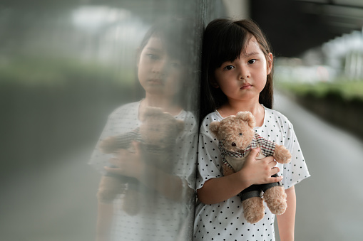 Portraits sad and unhappy Toddler girl holding teddy bear