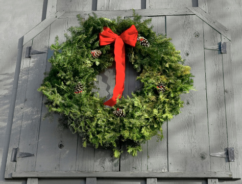 Christmas/Holiday wreath hangs on loft door of grey barn