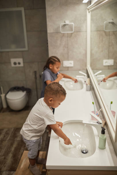 istock Brother and Sister Brushing Teeth 1403951697