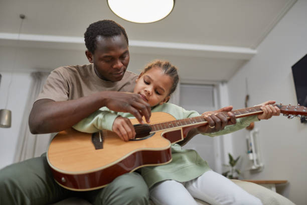 istock African American Father and Daughter Playing Guitar 1403951720