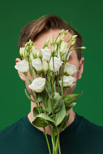 istock Man Hiding face with Flowers 1403952408