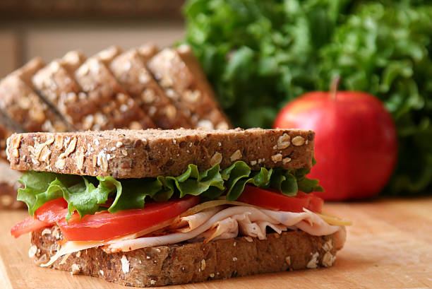 Lunch Healthy sandwhich made with whole grain bread, lettuce, tomato, cheese, and roasted chicken slices. sandwich healthy lifestyle healthy eating bread stock pictures, royalty-free photos & images