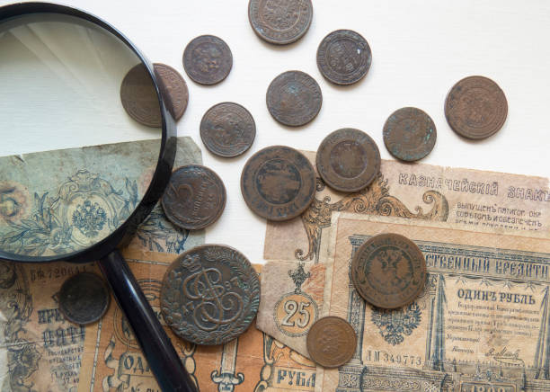 pila de monedas vintage de metal (cobre).  lupa y monedas del imperio ruso en el fondo - brass eagle fotografías e imágenes de stock